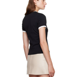 Woman wearing black and white contrast t-shirt with cream skirt — Courrèges | Endless UAE