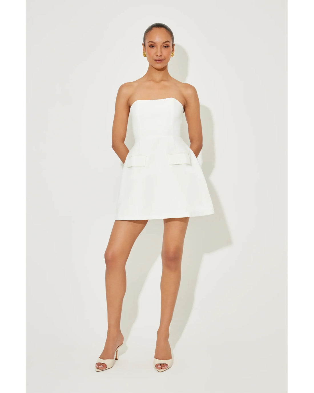 Woman wearing a white strapless dress with pockets and a flared skirt — Odd Muse | Endless UAE