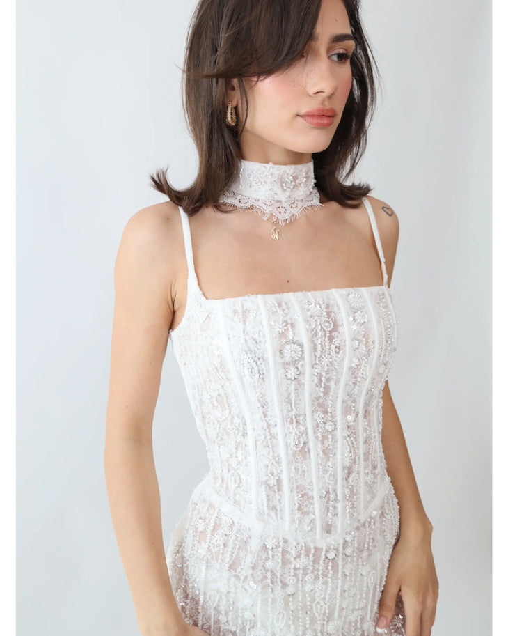 Woman wearing white lace embellished mini dress with choker and rhinestone heels — Millie Modelli | Endless UAE