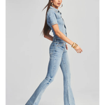 Woman wearing light blue denim Fallon Jumpsuit with short sleeves and flared legs — SER.O.YA | Endless UAE