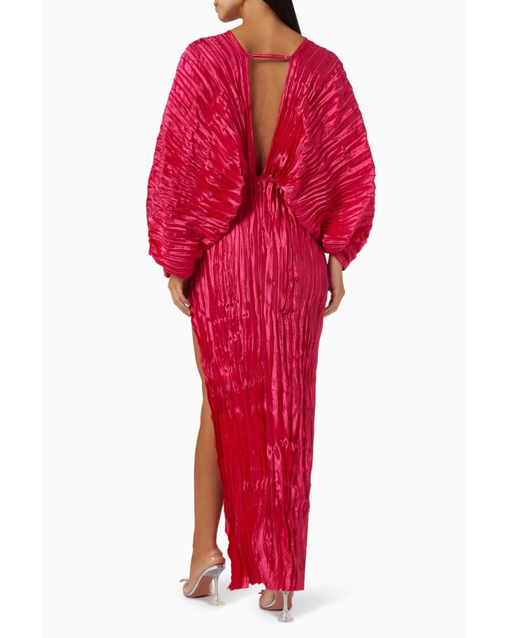 Woman wearing a fuchsia crinkled pleated oversized maxi dress with wrap front and voluminous sleeves — L'IDÉE | Endless UAE
