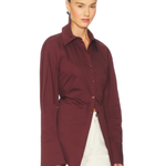 Burgundy poplin button-up shirt styled with cream trousers and black bag — Simon Miller | Endless UAE