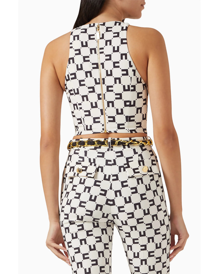 Woman wearing geometric patterned crop top and pants with black accessories — Elisabetta Franchi | Endless UAE