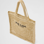 Natural raffia woven tote bag with open mesh design, black triangle logo, and structured shoulder straps — Prada | Endless UAE