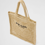 Natural raffia woven tote bag with open mesh design, black triangle logo, and structured shoulder straps — Prada | Endless UAE