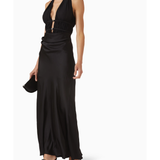 Woman wearing black halter maxi dress with ruched waist detail and silver accent — Misha | Endless UAE