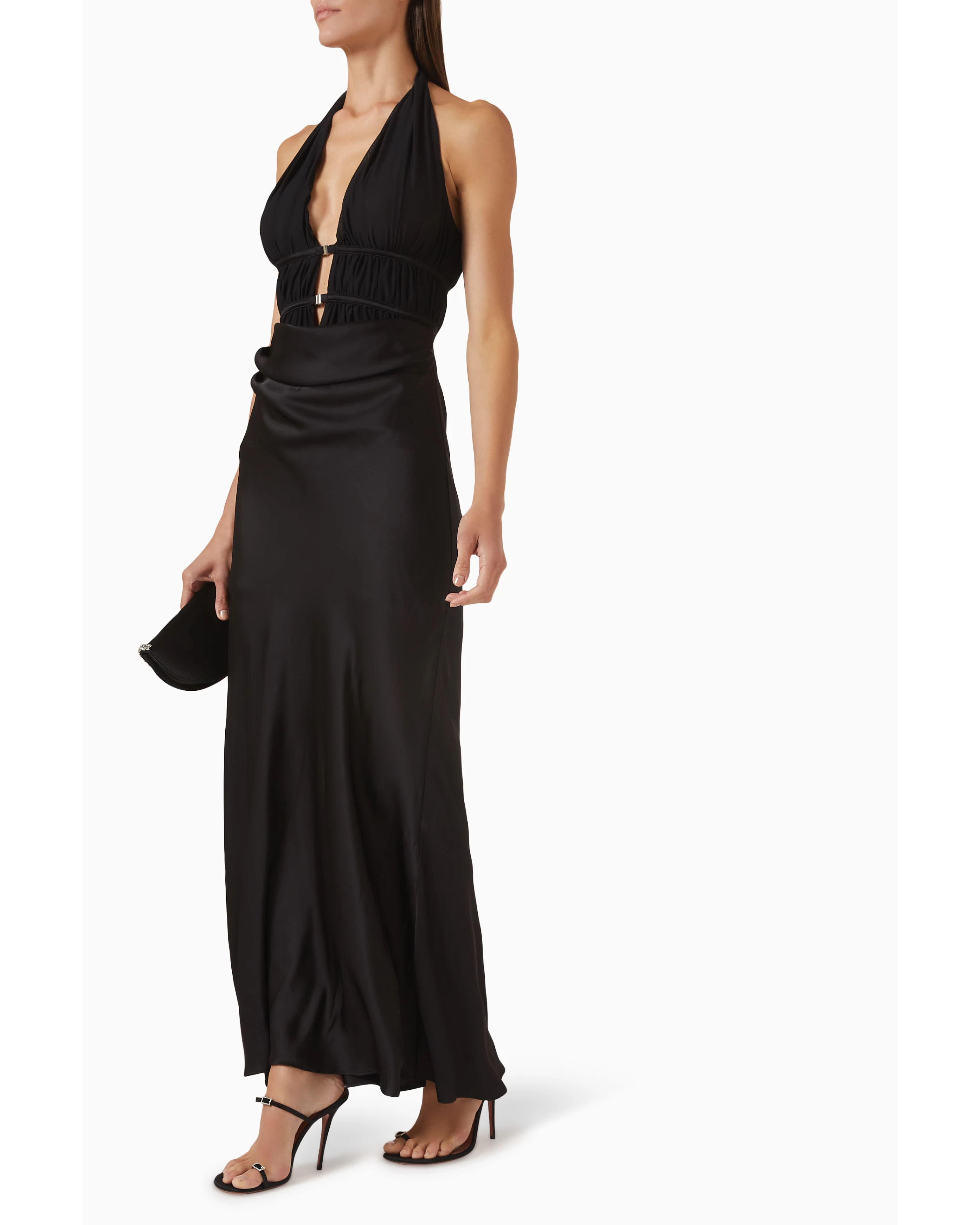 Woman wearing black halter maxi dress with ruched waist detail and silver accent — Misha | Endless UAE