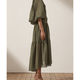 Olive green midi dress with high neck, puffed sleeves, tiered skirt, and textured fabric on model from side view — Shona Joy | Endless UAE