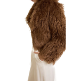 Woman wearing camel-colored fur stole jacket over cream top and pants with burgundy shoes — Madame Magdalena | Endless UAE