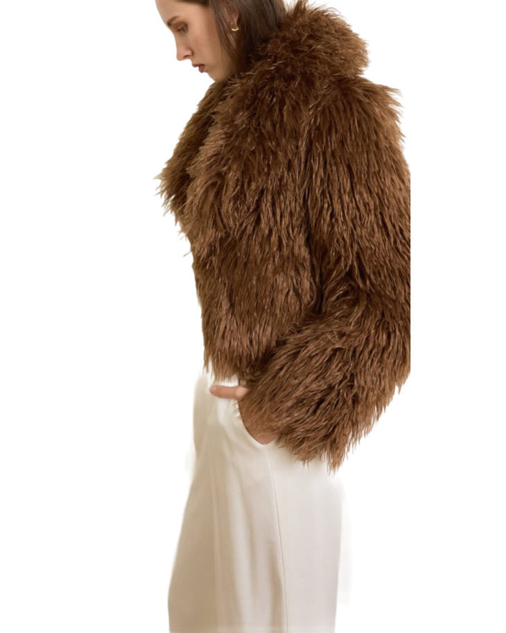 Woman wearing camel-colored fur stole jacket over cream top and pants with burgundy shoes — Madame Magdalena | Endless UAE