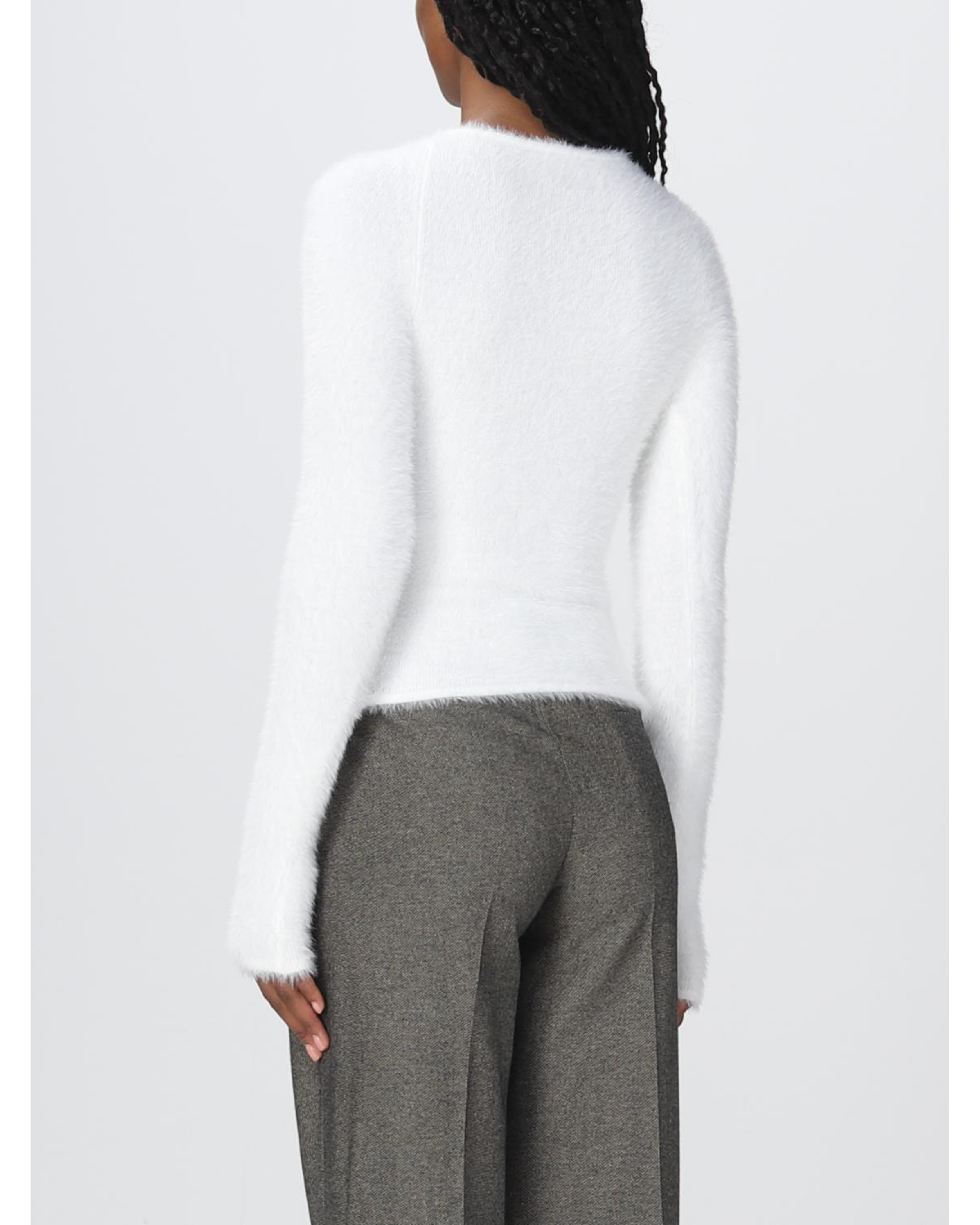 Rear view of model wearing white fluffy knit sweater with gray trousers — Coperni | Endless UAE