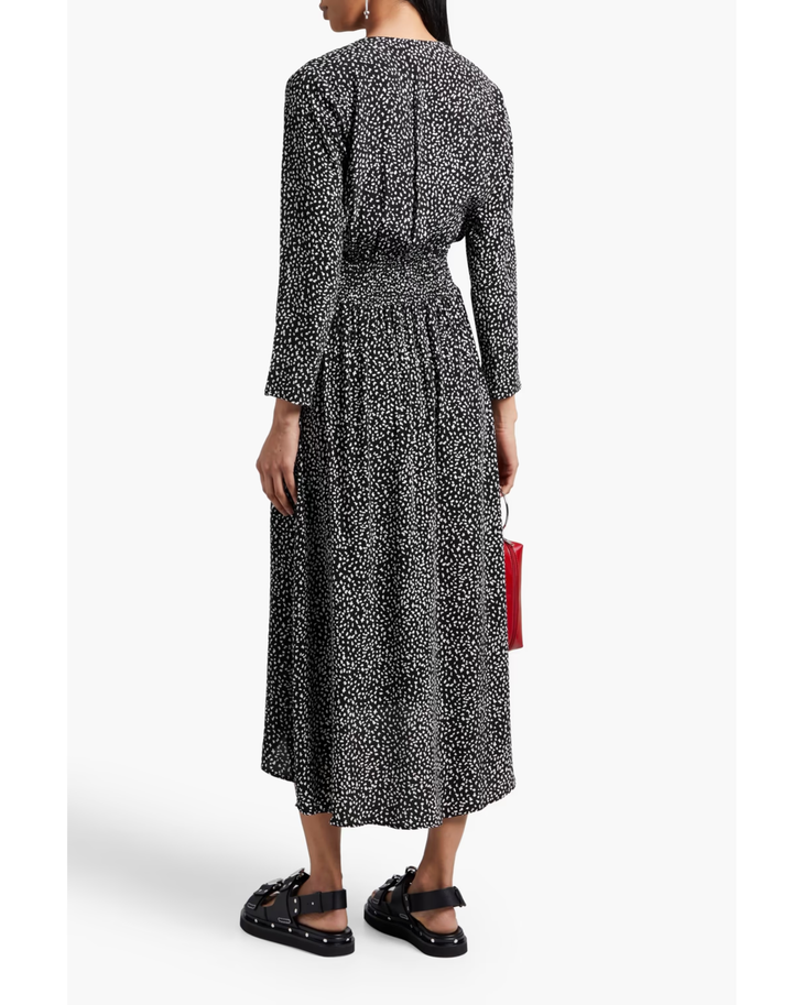 Black and white spotted midi dress with long sleeves, elasticated waist, and flowing skirt worn with sandals — Maje | Endless UAE