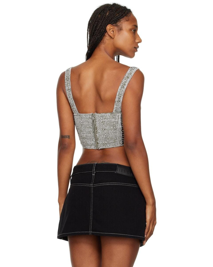 Model wearing silver crochet corset top with exposed back zipper and black mini skirt, back view — Dion Lee | Endless UAE