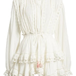 Woman wearing white eyelet cotton mini dress with long sleeves and layered skirt — LoveShackFancy | Endless UAE
