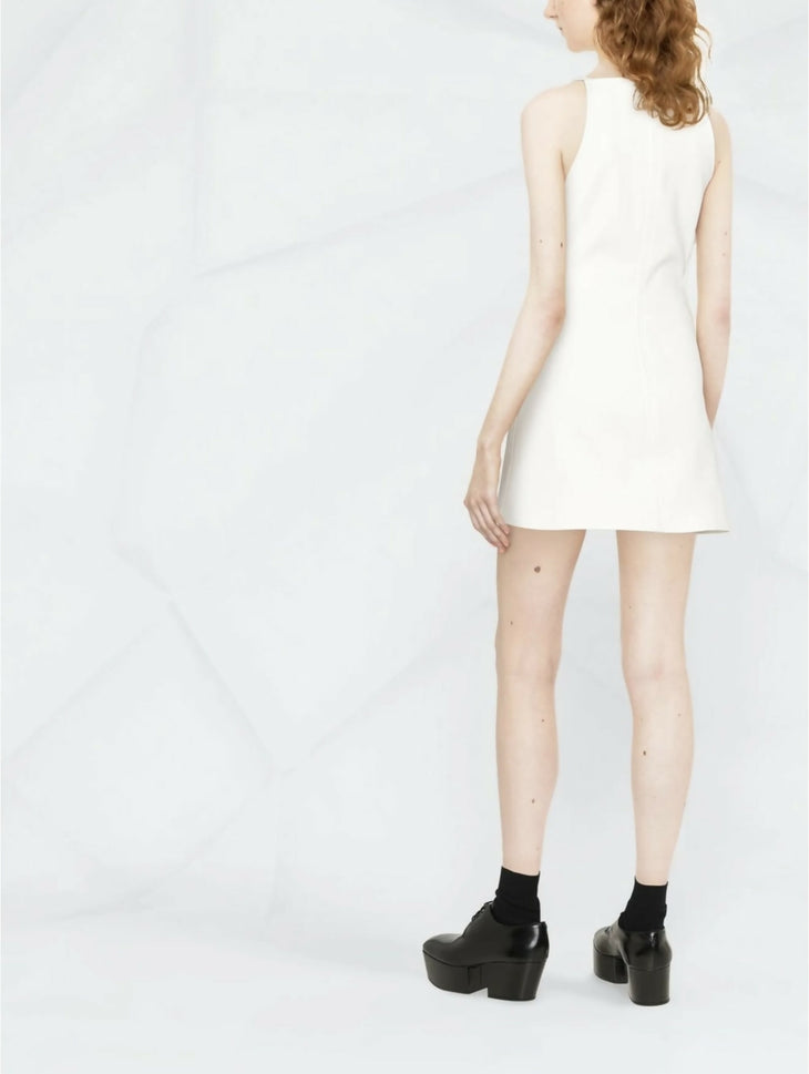 Woman wearing white sleeveless mini dress with cut-out detail, shown from back, paired with black platform shoes — Courrèges | Endless UAE
