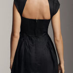 Black linen mini dress with cap sleeves and open back cutout detail, shown from behind — Reformation | Endless UAE