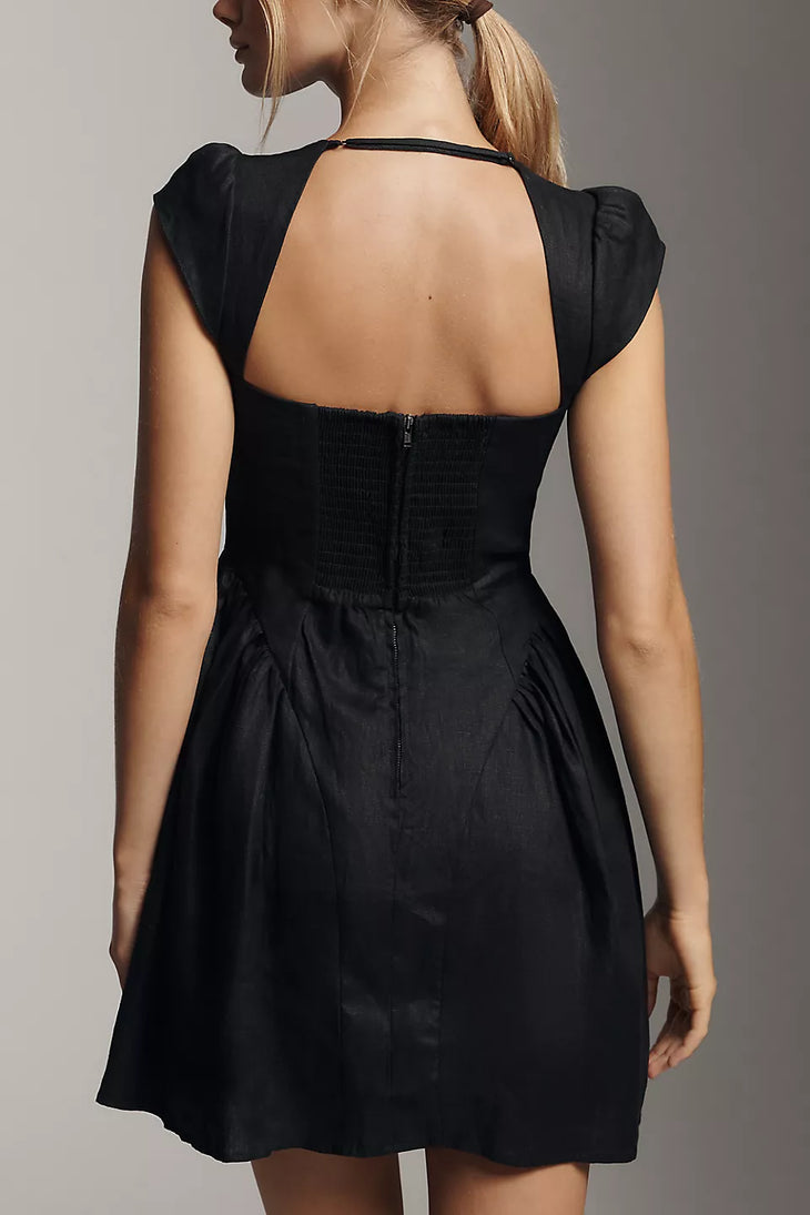Black linen mini dress with cap sleeves and open back cutout detail, shown from behind — Reformation | Endless UAE