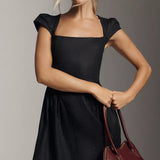 Black linen mini dress with square neckline and cap sleeves, styled with burgundy handbag — Reformation | Endless UAE