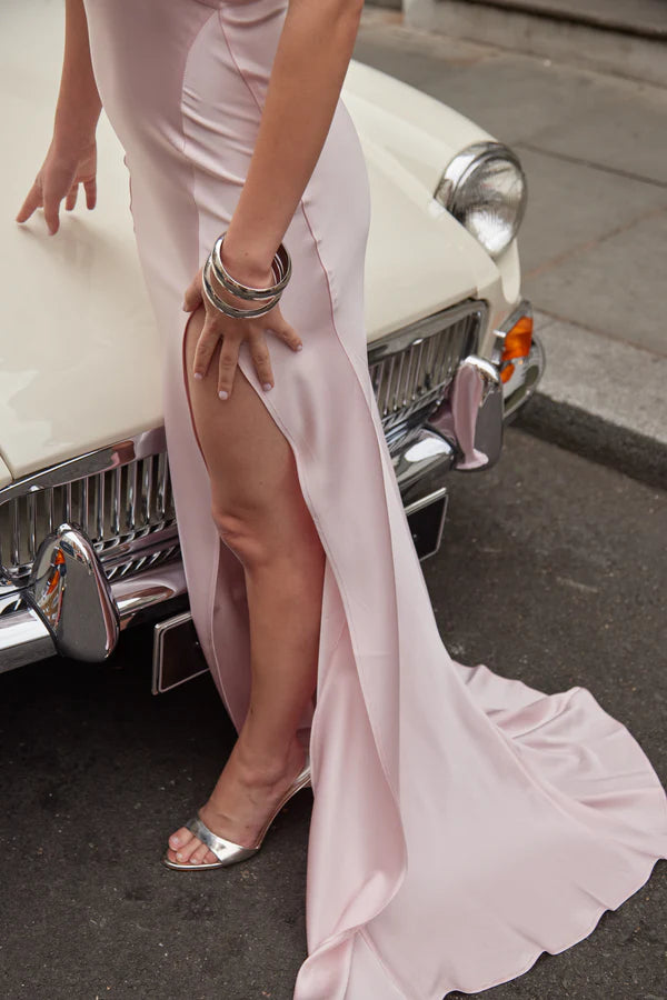 Elegant pale pink backless maxi dress with high slit and metallic accessories beside vintage car — By Keara | Endless UAE