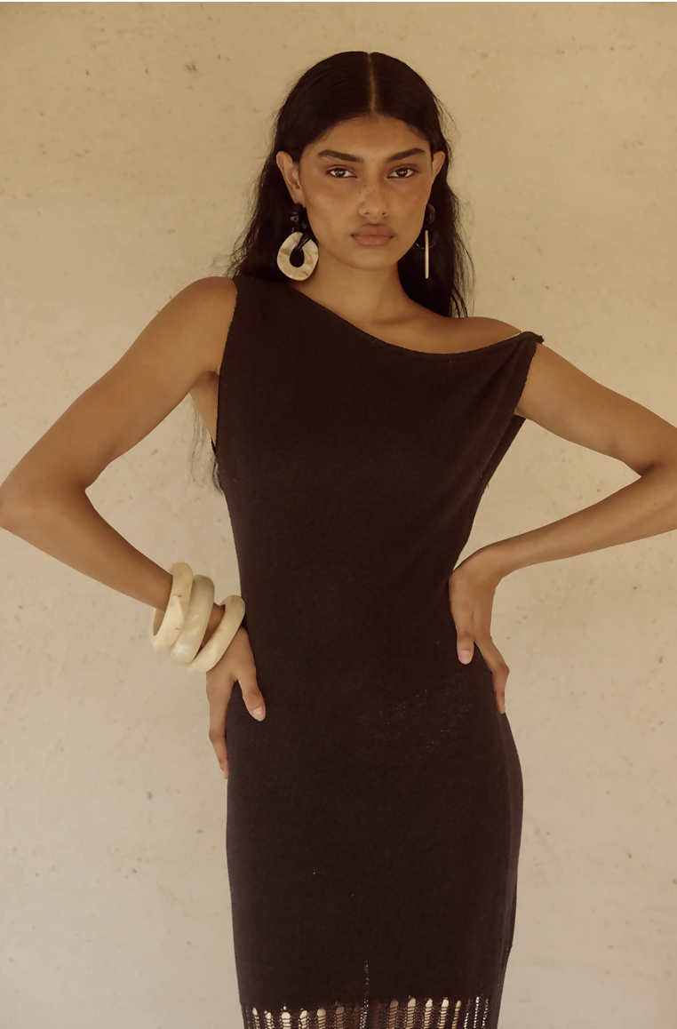 Woman wearing black off-shoulder knit maxi dress with fringe hem and white bangles — Endless | Endless UAE