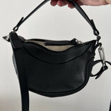 Black leather mini shoulder bag with textured finish held open to show interior — By Far | Endless UAE