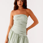 Woman wearing sage green strapless bubble mini dress with ruched detailing — Peppermayo | Endless UAE