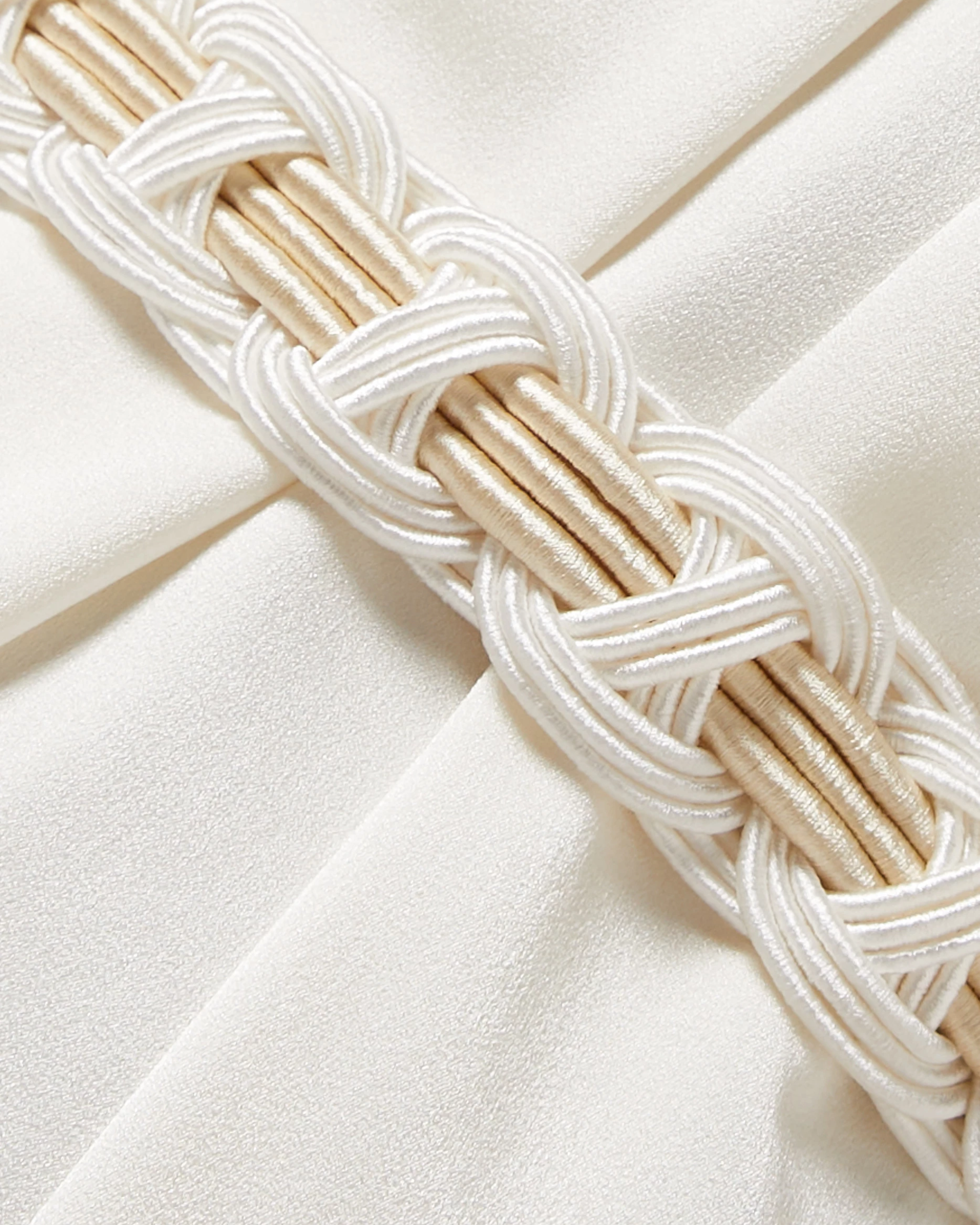 Elegant cream braided belt detail with interwoven design on ivory fabric background — Nass | Endless UAE