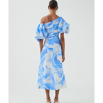 Woman wearing blue and white abstract print Cadence Ruched Midi Dress with puffed sleeves and white slides — Aje | Endless UAE
