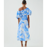 Woman wearing blue and white abstract print Cadence Ruched Midi Dress with puffed sleeves and white slides — Aje | Endless UAE