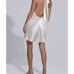 Woman wearing champagne pleated halterneck mini dress with deep V-neckline and metallic heeled sandals — L'IDÉE | Endless UAE