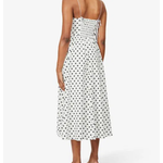 Woman wearing white polka-dot spaghetti-strap midi dress with smocked back and black heeled mules, back view — Reformation | Endless UAE