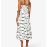 Woman wearing white polka-dot spaghetti-strap midi dress with smocked back and black heeled mules, back view — Reformation | Endless UAE