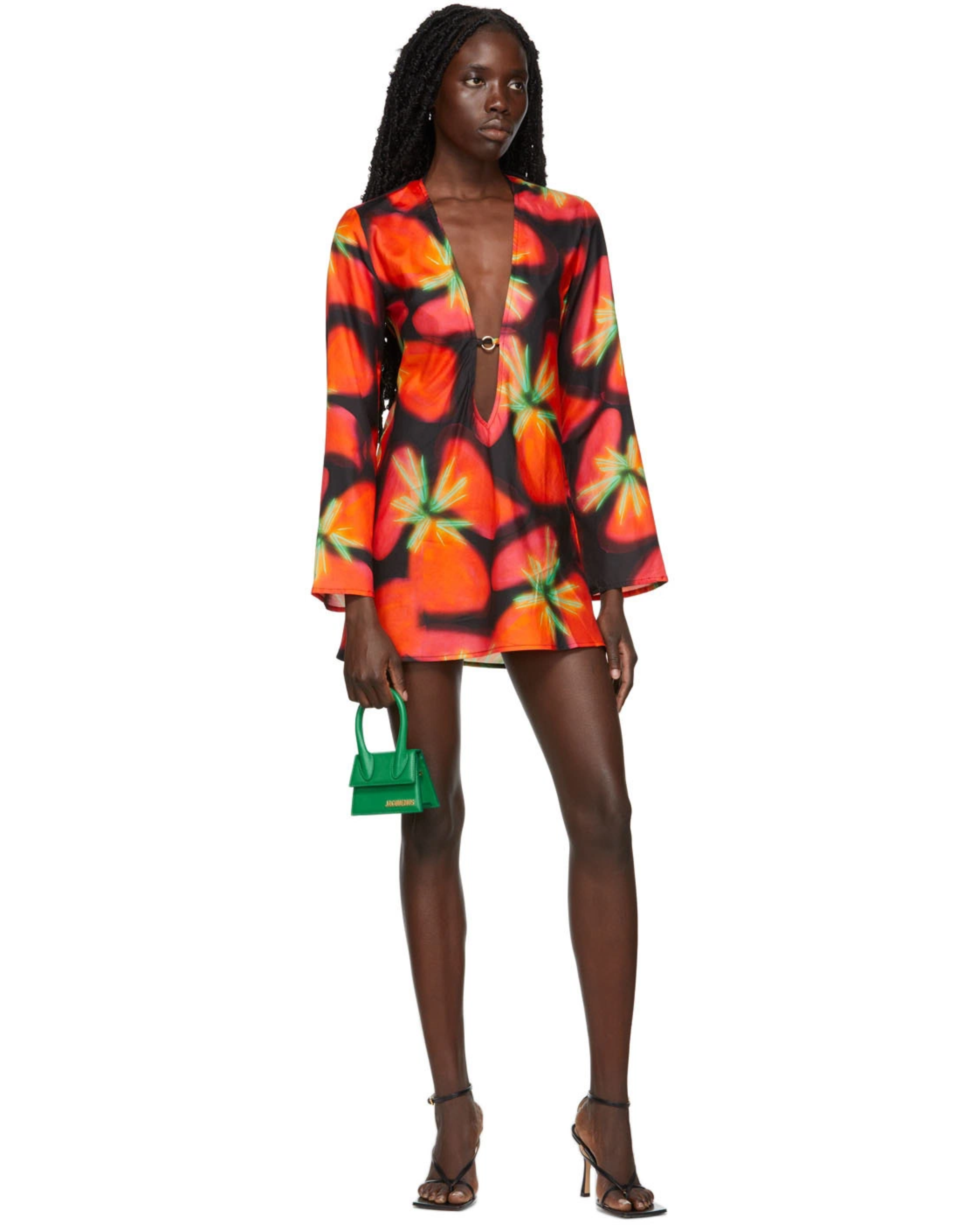 Woman wearing vibrant red and orange strawberry print blazer dress with green handbag — Louisa Ballou | Endless UAE