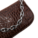 Dark brown croc-embossed mini shoulder bag with chain detail held in hand — By Far | Endless UAE