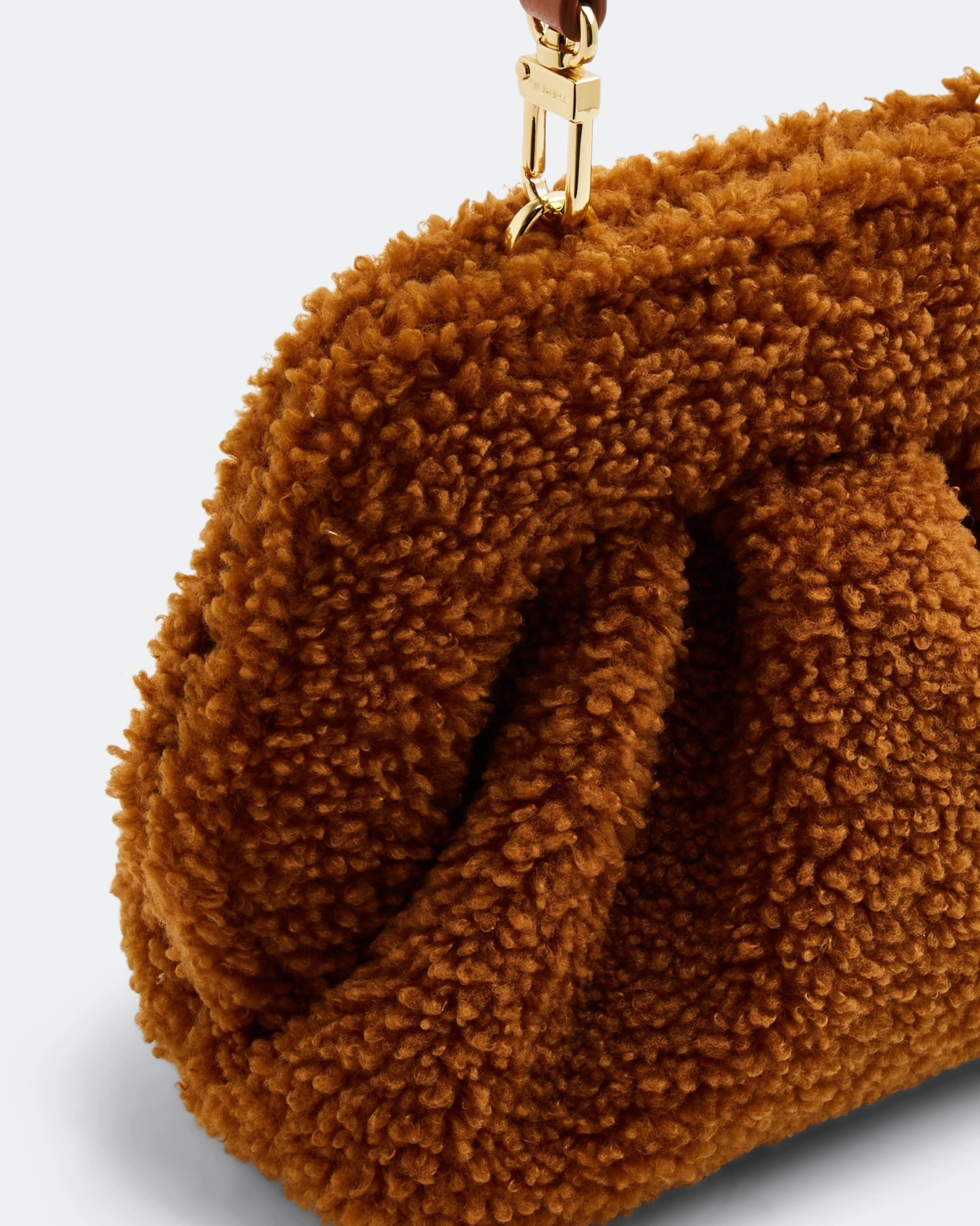 Gea Clutch in caramel brown textured fabric held in hand — TheMoire | Endless UAE
