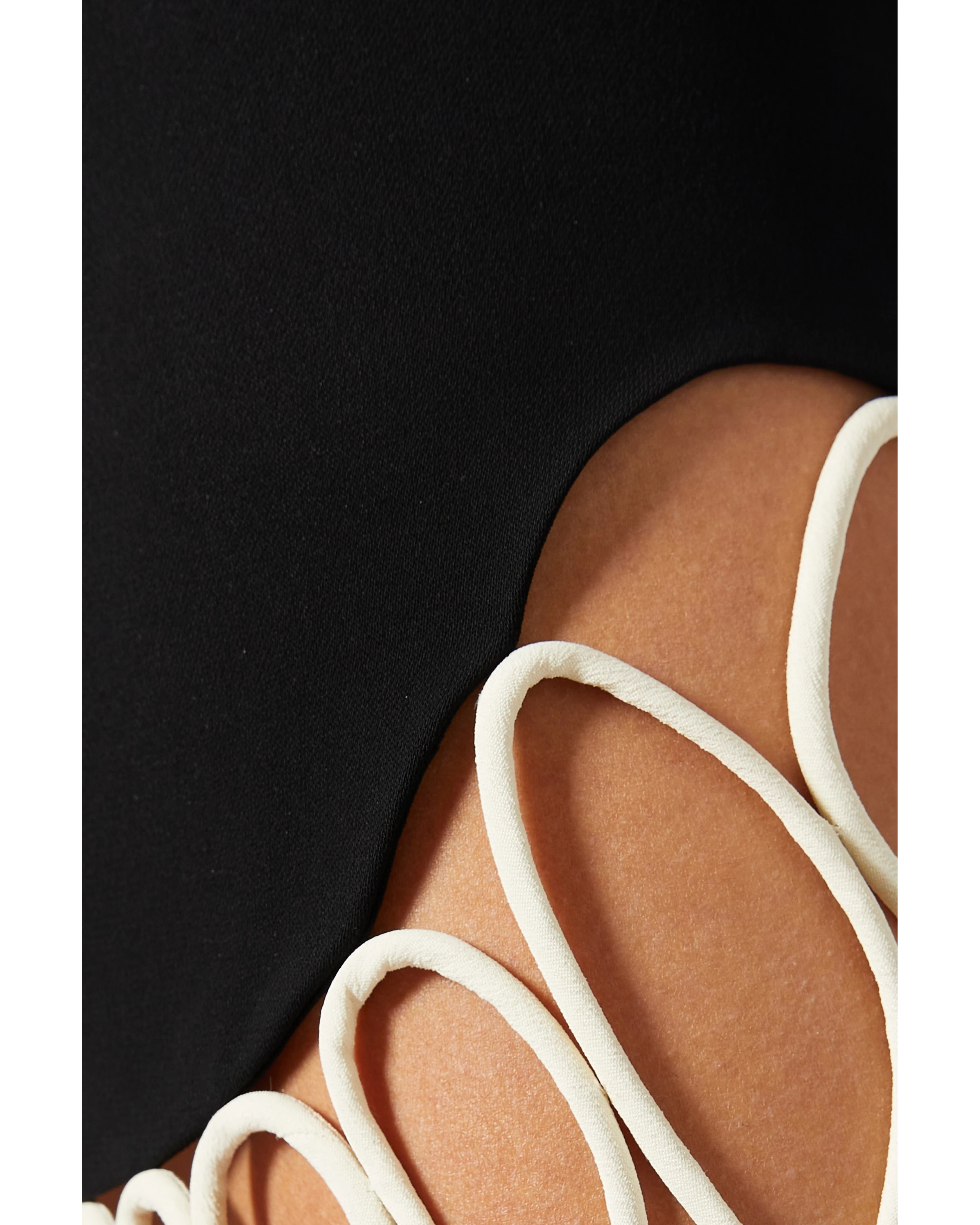 Black mini skirt with white wavy trim detail on leg — Nafsika Skourti | Endless UAE
