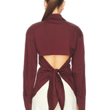 Burgundy poplin button-up shirt styled with cream trousers and black bag — Simon Miller | Endless UAE
