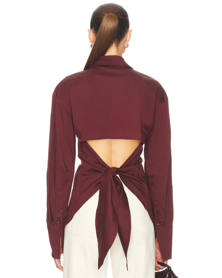 Burgundy poplin button-up shirt styled with cream trousers and black bag — Simon Miller | Endless UAE