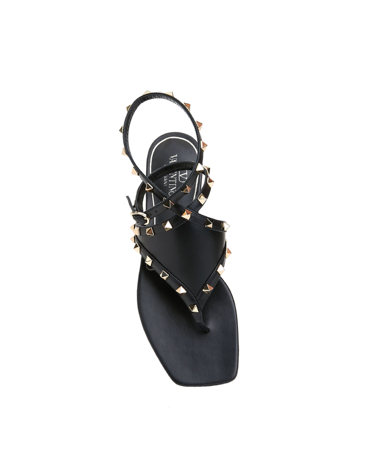 Black leather thong sandals with gold pyramid studs and ankle strap, viewed from above — Valentino Garavani | Endless UAE