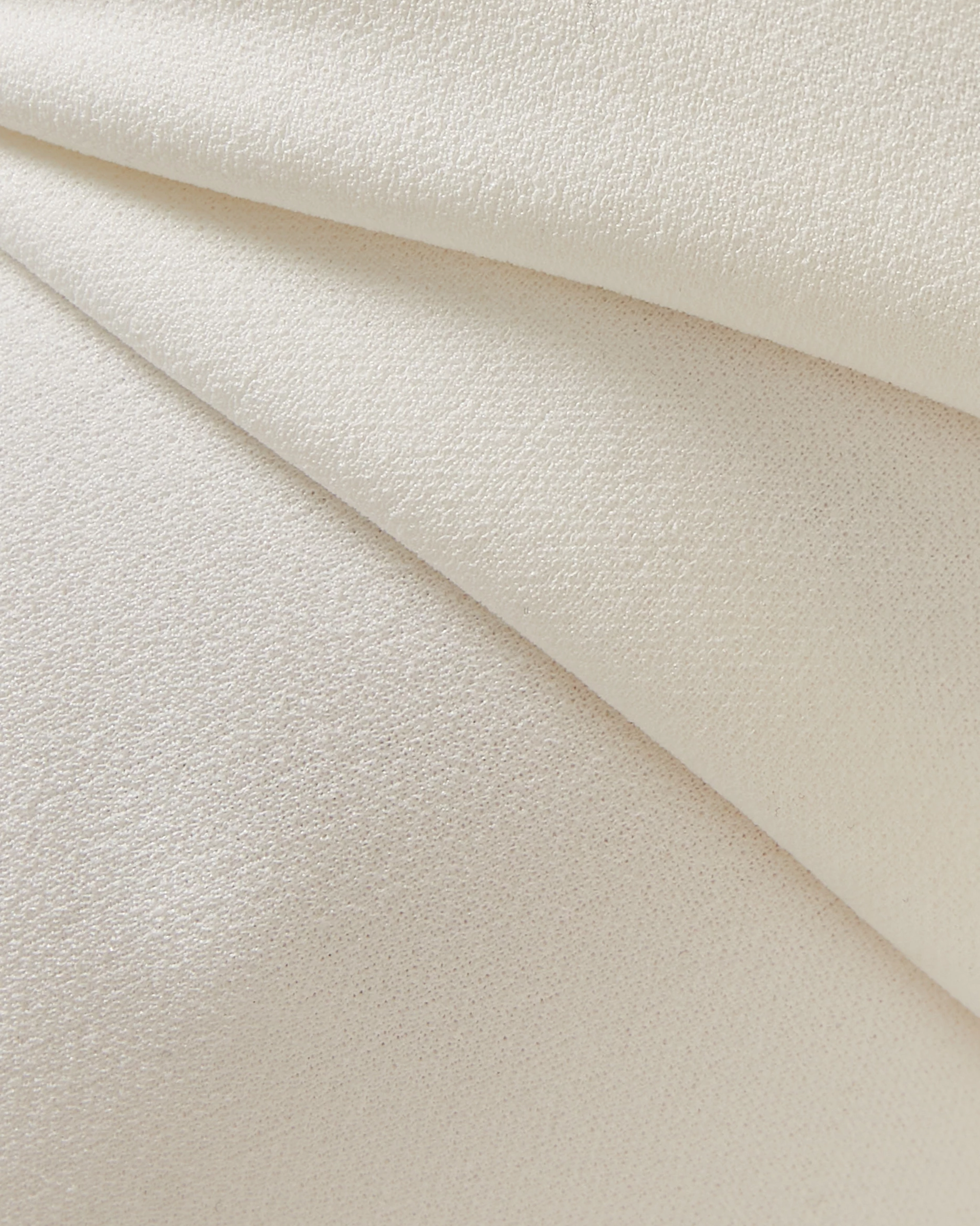 Elegant cream textured fabric with subtle sheen draped in soft folds showing luxurious material detail — Misha | Endless UAE