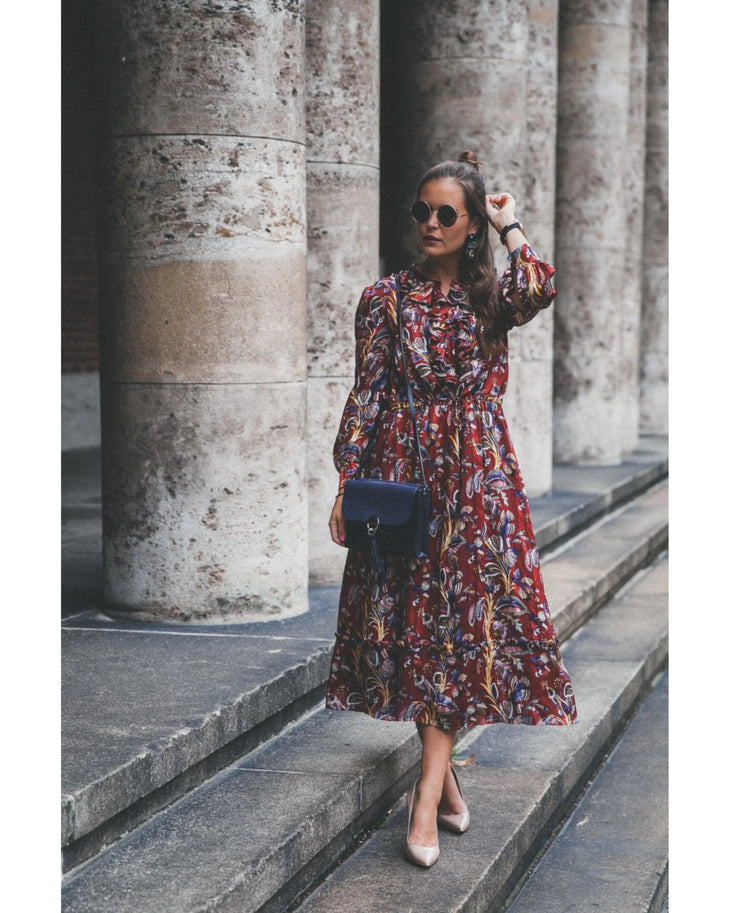 Woman wearing burgundy paisley maxi dress with white sneakers and sunglasses in urban setting — & Other Stories | Endless UAE