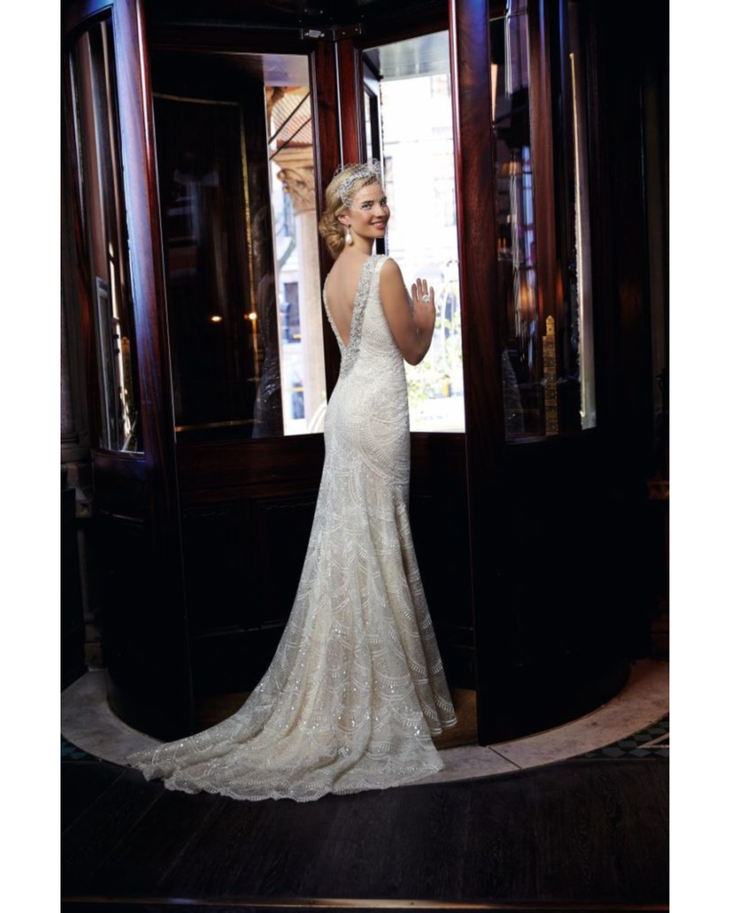Elegant beaded lace mermaid wedding dress with illusion back and cathedral train by bride in doorway — Ronald Joyce | Endless UAE