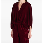 Woman wearing burgundy silk velvet jumpsuit with ornamental detailing and wide legs — Themis-Z | Endless UAE