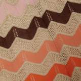 Woman wearing a colorful striped cotton jumpsuit with orange, brown and cream zigzag pattern — Missoni | Endless UAE