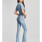 Woman wearing light blue denim Fallon Jumpsuit with short sleeves and flared legs — SER.O.YA | Endless UAE