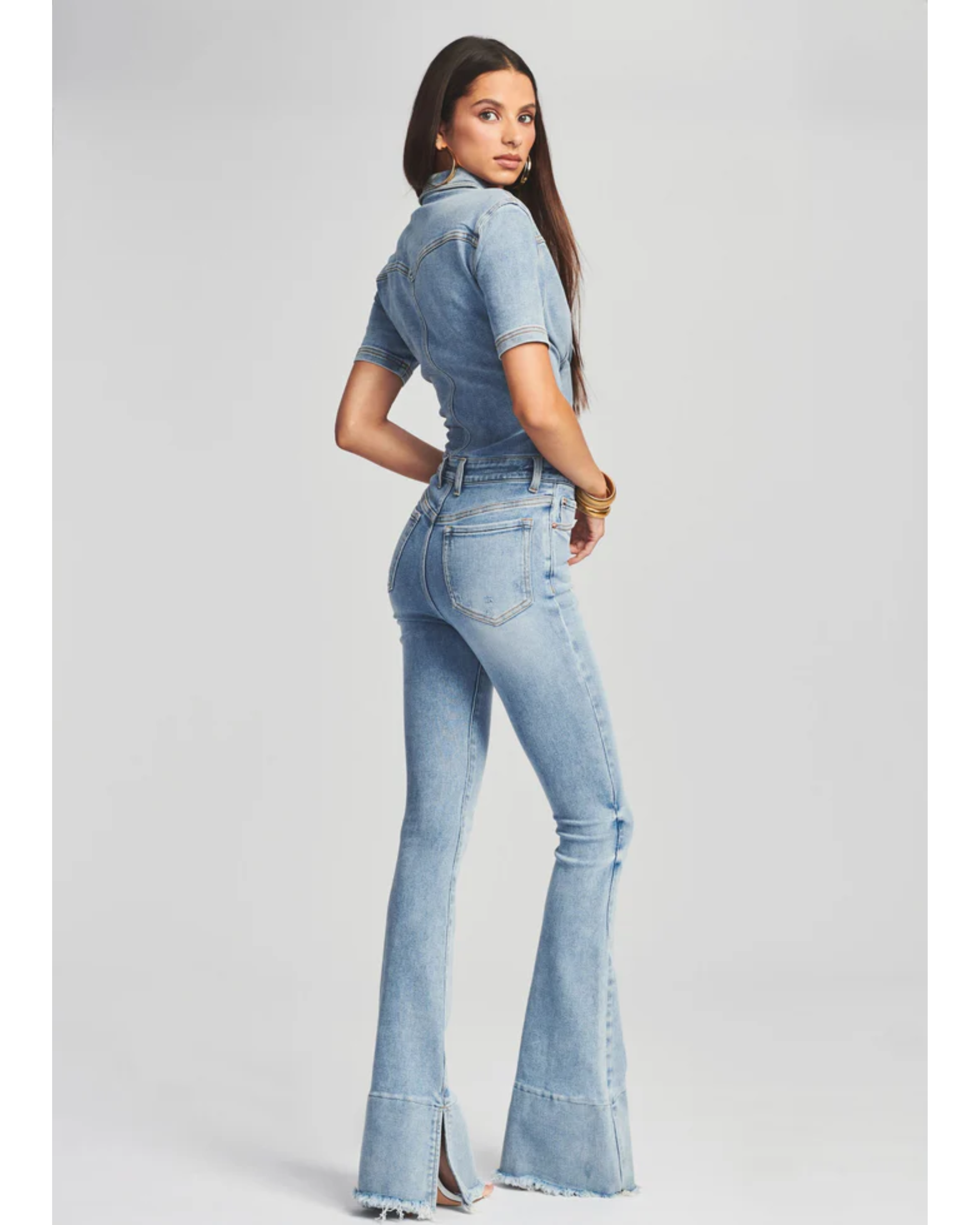 Woman wearing light blue denim Fallon Jumpsuit with short sleeves and flared legs — SER.O.YA | Endless UAE