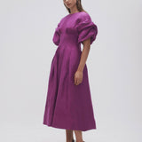 Woman wearing Adelie Puff Sleeve Midi Dress in plum with black strappy sandals — Aje | Endless UAE