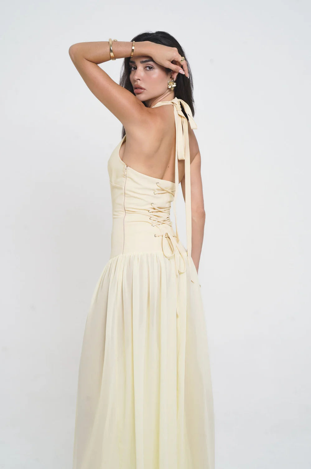Elegant pale yellow satin maxi dress with halter neck ties, corset-style lacing, and flowing drop-waist skirt — Vivienne Collection | Endless UAE