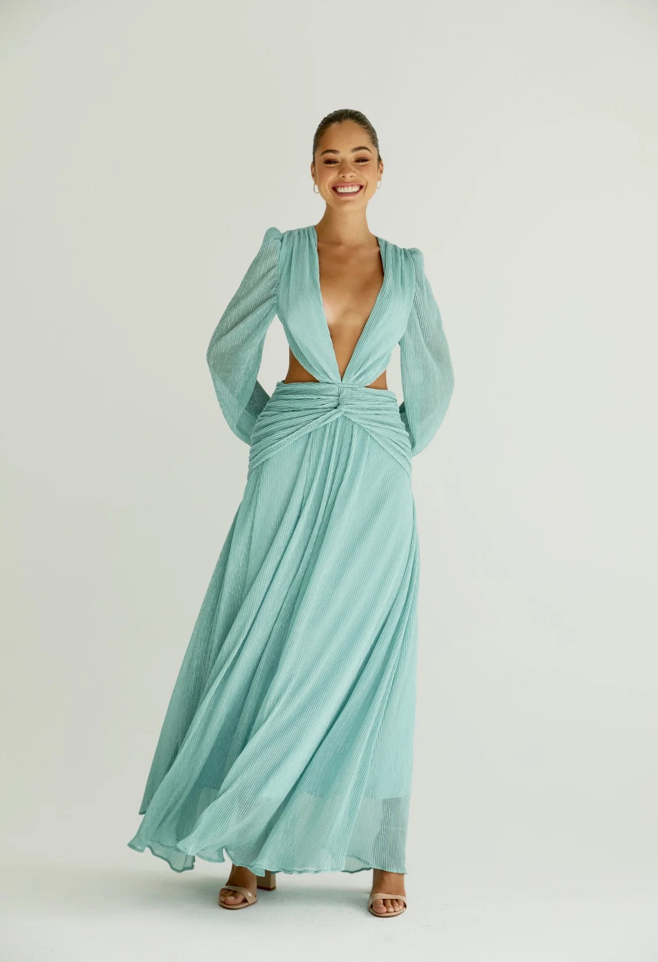 Woman wearing a flowing light blue wrap dress with long sleeves and cutout waist detail — Anne Louise Boutique | Endless UAE