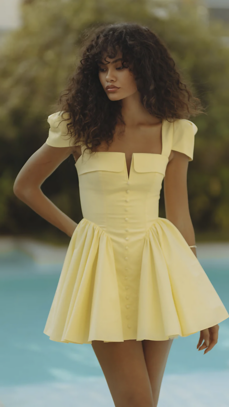 Woman wearing yellow off-shoulder mini dress with puffed sleeves by poolside — Endless | Endless UAE